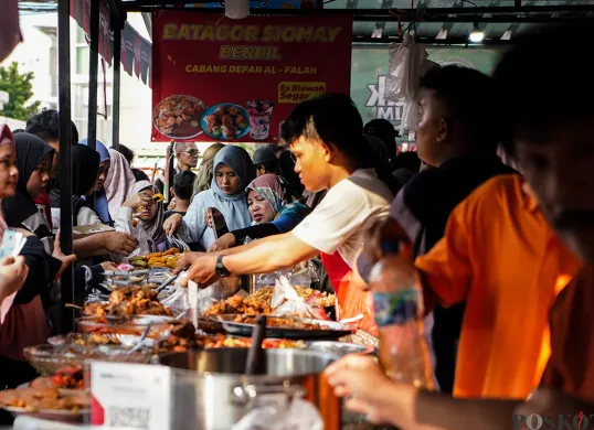 Pedagang melayani pembeli untuk berbuka di hari pertama puasa di pasar takjil Bendungan Hilir, Jakarta, Sabtu, 1 Maret 2025. Menariknya kini ada tradisi ngabuburit dan war takjil. (Sumber: Poskota/Bilal Nugraha Ginanjar)