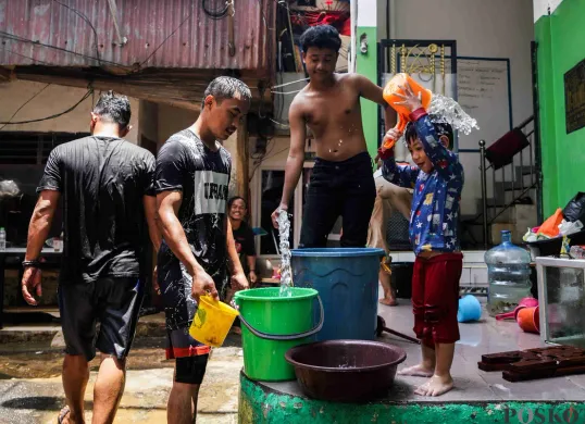 Warga membersihkan diri dan perabotan rumahnya pascabanjir di Kampung Melayu, Jatinegara, Jakarta Timur, Rabu, 5 Maret 2025. (Sumber: Poskota/Bilal Nugraha Ginanjar)