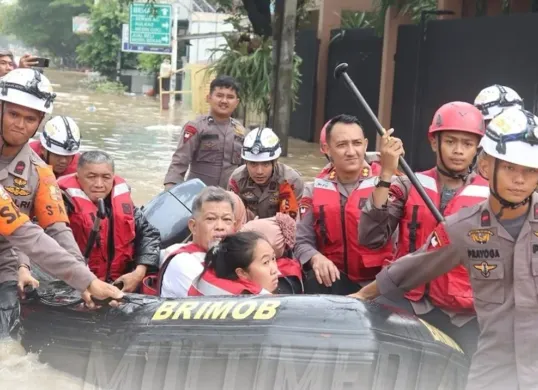 Personel Brimob melakukan evakuasi terhadap korban banjir di kawasan Bekasi. (Sumber: Dok Humas Polri)