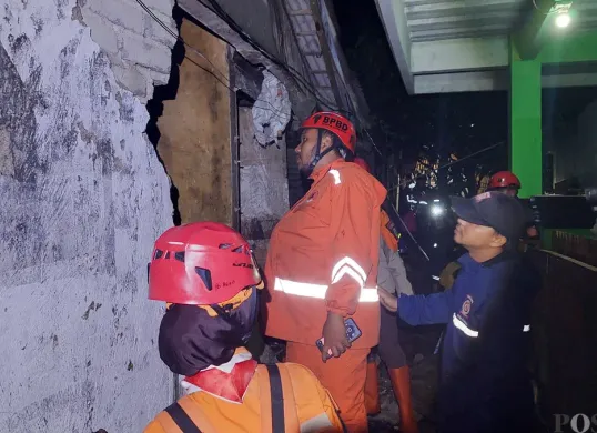 Petugas BPBD Kota Cimahi saat melakukan evakuasi dan assesment di lokasi kejadian, di RW 10 Cireundeu, Kecamatan Cimahi Selatan, Kota Cimahi. Jumat 7 Maret 2025, malam. (Sumber: Poskota/Gatot Poedji Utomo)