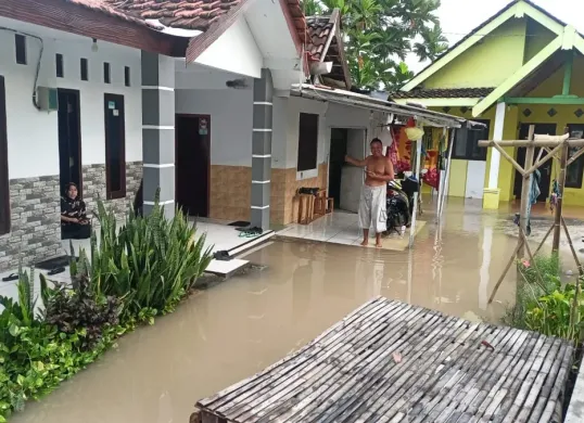 Seorang warga Probolinggo berada di teras rumah yang terendam banjir, BNPB melaporkan satu orang meninggal dunia akibat bencana banjir tersebut. (Sumber: Dok BNPB)