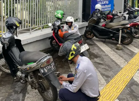 Petugas Dishub Kota Depok melakukan penertiban motor parkir liar diatas trotoar sepanjang Jalan Margonda. (Sumber: Dok. Dishub Kota Depok)