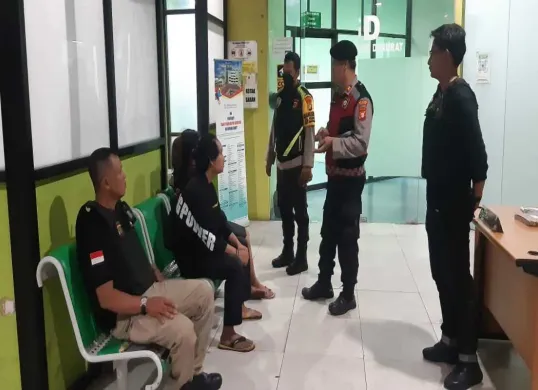 Petugas Polsek Bojongsari dibantu Mitra Pokdarkamtibmas mengamankan pelaku yang mengalami luka pada tangan di RSUD Depok usai mengamuk merusak toko vape. (Sumber: Dok. Polsek Bojongsari)