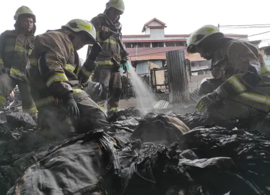 Petugas dari Suku Dinas Penanggulangan Kebakaran dan Penyelamatan Jakarta Pusat melakukan pendinginan pada kebakaran di Pasar Poncol Jakarta. (Sumber: Poskota/Bilal Nugraha Ginanjar)