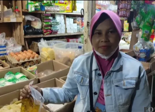 Mimin berkeliling dari satu warung ke warung lain untuk mencari MinyaKita, hingga akhirnya hanya dapat satu bungkus dengan harga yang lebih tinggi dari biasanya. (Sumber: Poskota/Samsul Fatoni)