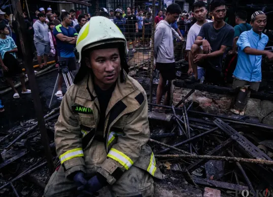 Petugas pemadam kebakaran beristirahat setelah melakukan pemadaman di Pasar Poncol, Senen, Jakarta Pusat, Selasa, 18 Maret 2025. (Sumber: Poskota/Bilal Nugraha Ginanjar)