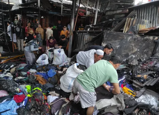 Sejumlah pedagang mengais sisa barang setelah kebakaran melanda puluhan kios pakaian di Pasar Poncol, Senen, Jakarta Pusat, Selasa, 18 Maret 2025. (Sumber: Poskota/Ade Mamad)