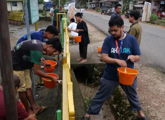 Beberapa Relawan saat melakukan kegiatan gotong royong mengecat pagar masjid bersama masyarakat setempat di Desa Banyuasin, Kecamatan Riau Silip, Kabupaten Bangka, Kepulauan Bangka Belitung, Sabtu, 15 Maret 2025. (Sumber: Dok. Telkom)