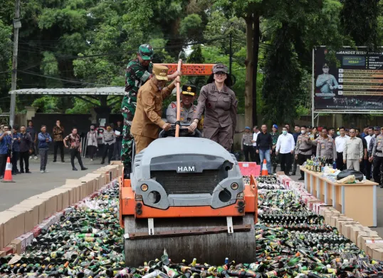 Pemusnahan minuman keras hasil operasi pekat maung selama satu bulan lebih di halaman Mapolda Banten, Kamis, 20 Maret 2025. (Sumber: Dok. Bidhumas Polda Banten)