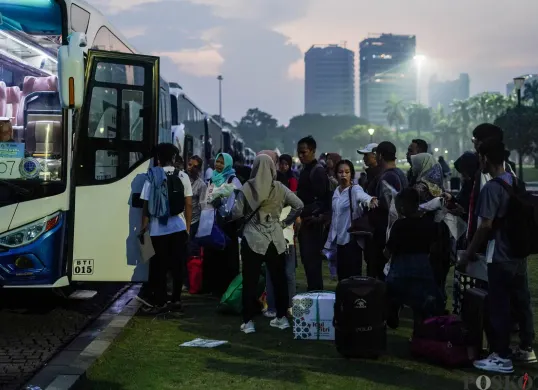 Sejumlah pemudik bersiap menaiki bus dalam program Mudik Gratis saat senja. Dengan membawa barang bawaan, mereka tampak bersemangat untuk pulang ke kampung halaman. (Sumber: Poskota/Bilal Nugraha Ginanjar)