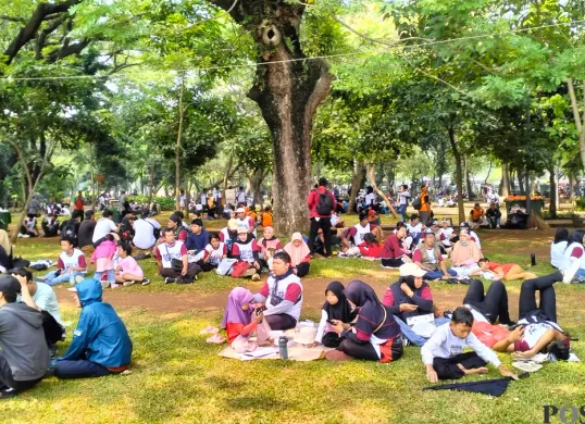 Massa aksi sedang berteduh di bawah pohon di Kawasan Monas, Jakarta Pusat, Kamis 1 Mei 2025. (Sumber: Poskota/M. Tegar Jihad)