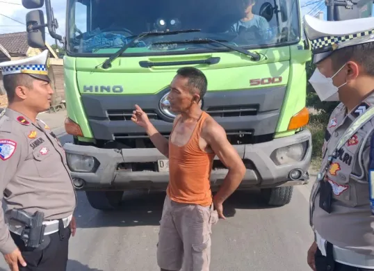 Personel Satlantas Polres Serang meminta sopir angkutan tanah di jalan raya Cirabit. (Sumber: Dok. Satlantas Polres Serang)