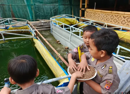 Anak-anak di sekolah alam terlihat gembira saat belajar di luar. Mereka bisa berinteraksi langsung dengan tanaman, ikan, hingga hewan ternak. (Sumber: Poskota/Nurpini Aulia Rapika)