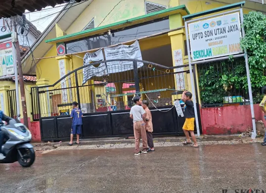 Sejumlah anak tampak bermain di depan SDN Utan Jaya Depok yang disegel oleh ahli waris. (Sumber: Poskota/Angga Pahlevi)