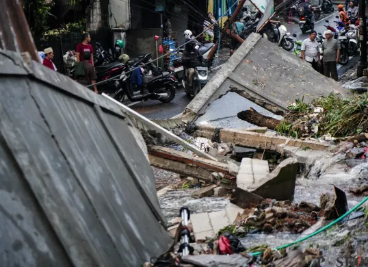 Tembok pembatas sepanjang 12 meter di Kalibata Timur Raya, Jakarta Selatan ambruk karena tersumbatnya kali yang tepat berada di belakangnya. (Sumber: Poskota/Bilal Nugraha Ginanjar)