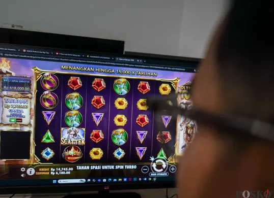 Seorang warga bermain judi online di kawasan perkantoran Palmerah, Jakarta Barat, Jum'at, 9 Mei 2025. PPATK mencatat transaksi judi online di Jakarta menjadi salah satu yang tertinggi di seluruh Indonesia. (Sumber: Poskota/Bilal Nugraha Ginanjar)