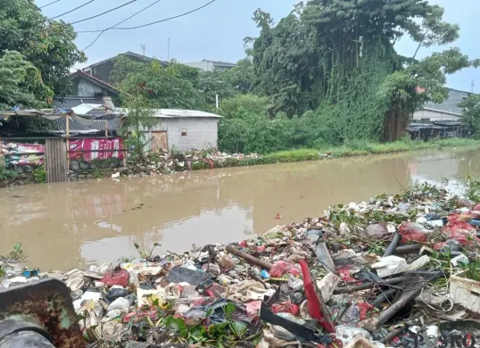 Air kali di Jalan, Teluk Pucung, Bekasi Utara, Kabupaten Bekasi meluap seusai diterjang hujan deras sejak pagi hari, Sabtu, 10 Mei 2025. (Sumber: Poskota/Nurpini Aulia Rapika)