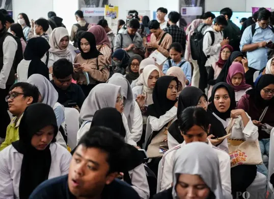 Pencari kerja melihat lowongan pekerjaan di salah satu stan perusahaan di GOR Kemayoran, Jakarta, Selasa, 6 Mei 2025. (Sumber: Poskota/Bilal Nugraha Ginanjar)