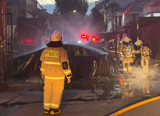 Petugas memadamkan api yang membakar mobil listrik milik warga di Palmerah, Jakarta Barat, Selasa, 13 Mei 2025. (Sumber: Dok. Damkar Jakarta Barat)