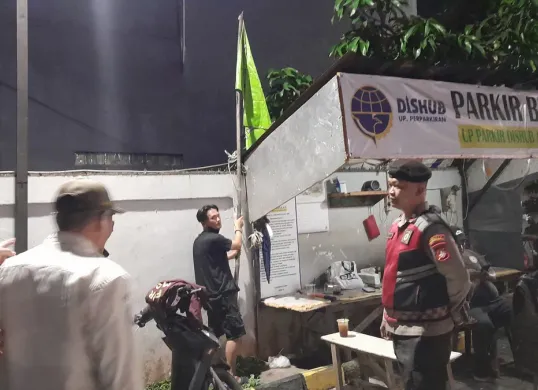 Polsek Cipayung bersama Satpol PP menertibkan bendera ormas yang terpasang di rumah makan. (Sumber: Dok. Humas Polsek Cipayung)