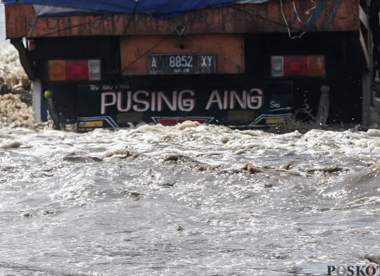 Ilustrasi Banjir - Sejumlah kendaraan berupaya melintasi jalan yang tergenang banjir rob di kawasan Pelabuhan Sunda Kelapa, Jakarta Utara, Rabu, 14 Mei 2025. (Sumber: Poskota/Bilal Nugraha Ginanjar)