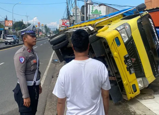 Satu unit truk bermuatan bahan bangunan anjlok ke dalam gorong-gorong depan salah satu toko di Bojongsari, Kota Depok, Rabu, 14 Mei 2025. (Sumber: Polsek Bojongsari)