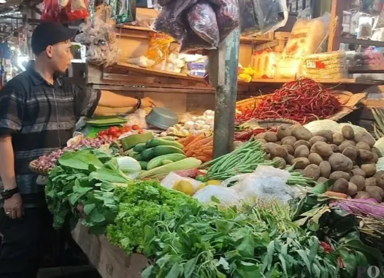 Salah seorang pedagang sayur mayur di Pasar Badak Pandeglang, saat menata barang dagangannya. (Sumber: Poskota/Samsul Fatoni)