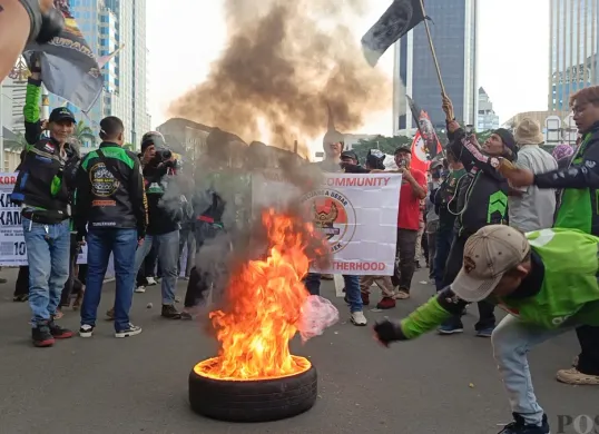 Aksi driver ojek online (Ojol) membakar ban bekas di kawasan Patung Kuda atau Patung Kuda Arjuna Wijaya, Jakarta Pusat, Selasa, 20 Mei 2025. (Sumber: Poskota/Ali Mansur)