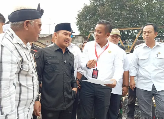 Bupati Bekasi Ade Kuswara Kunang meninjau lokasi kebakaran Pasar Bojong, Kedungwaringin, Kabupaten Bekasi, Rabu, 21 Mei 2025. Dalam peninjauan ini, Bupati Ade mendengar keluhan pedagang yang terdampak. (Sumber: Poskota/Nurpini Aulia Rapika)