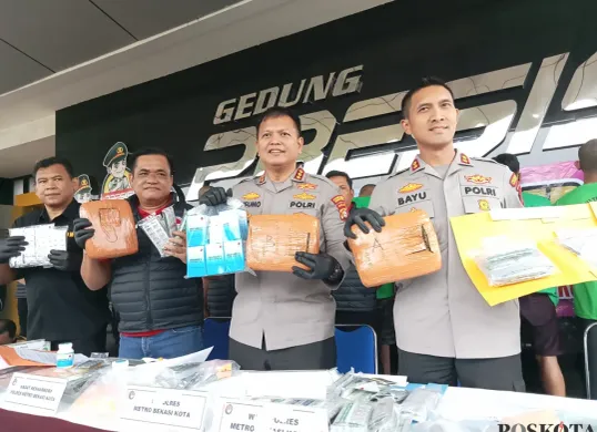 Barang bukti berupa 23.619 butir obat keras daftar G, buku catatan penjualan, alat tulis, enam unit handphone, dan uang tunai Rp5.190.000 yang disita polisi dari enam tersangka pengedar di Kota Bekasi. (Sumber: Poskota/Nurpini Aulia Rapika)