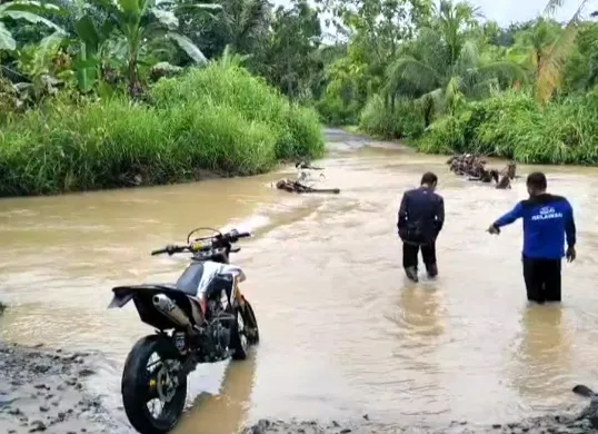 Sejumlah warga di Desa Cikeusik, Kecamatan Cikeusik, Pandeglang, saat hendak melintas jembatan yang terendam banjir. (Sumber: Dok. Warga)