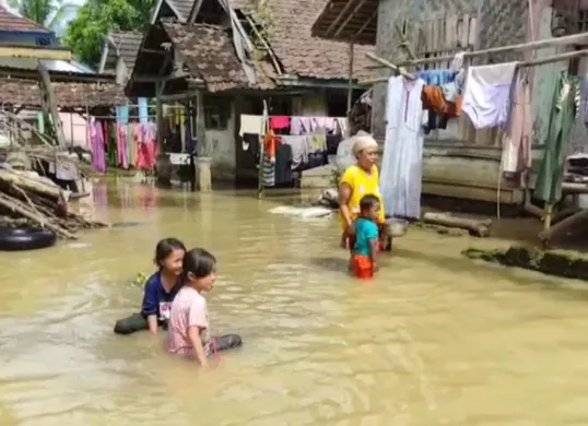 Sejumlah anak bermain air di tengah banjir yang merendam permukiman di Desa Idaman, Kecamatan Patia, Kabupaten Pandeglang, Selasa 27 Mei 2025. (Sumber: POSKOTA | Foto: Samsul Fatoni)