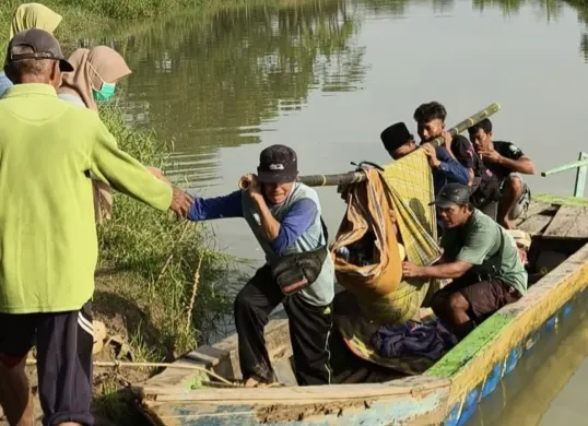 Sejumlah warga Kampung Ciluluk, Desa Leuwibalang, Kecamatan Cikeusik, Kabupaten Pandeglang, saat menandu pasien dari perahu kayu. (Sumber: Dok. Warga)