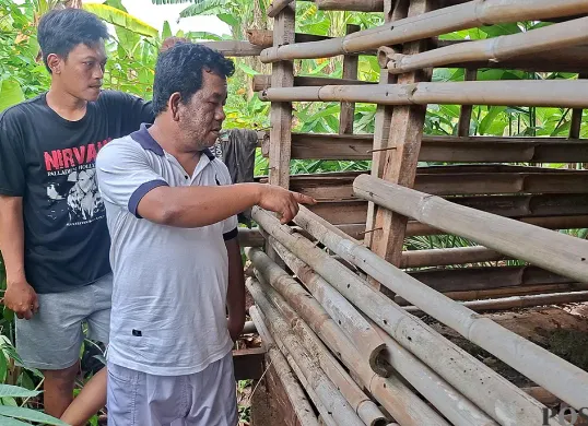 Fadilah (kanan) bersama warga menunjukan lokasi kandang kambing miliknya yang dirusak pelaku pencurian. (Sumber: POSKOTA | Foto: Angga Pahlevi)