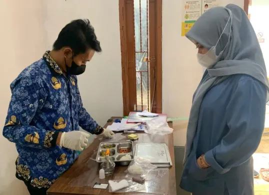 Ahli gizi dan pihak Puskesmas Pagelaran, Kabupaten Pandeglang, mengambil sampel makanan untuk kelengkapan dokumen SLHS. (Sumber: Dok. SPPG Sindanglaya 2)