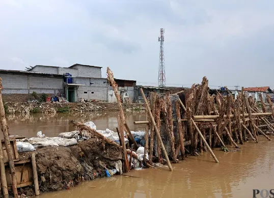 Kondisi Tanggul Kali Srengseng di Desa Sukamanah, Kecamatan Sukatani, Kabupaten Bekasi, tampak lebih surut debit airnya usai jebol pada Sabtu, 1 November 2025. (Sumber: POSKOTA | Foto: Nurpini Aulia Rapika)