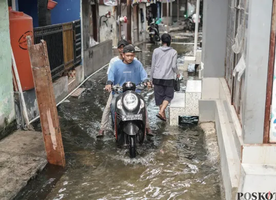 Ilustrasi, warga melintasi genangan banjir rob di Muara Angke, Jakarta Utara, Rabu, 5 November 2025. (Sumber: Poskota/Bilal Nugraha Ginanjar)