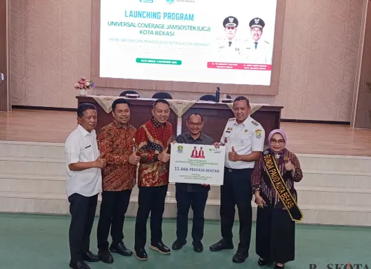 Wali Kota Bekasi Tri Adhianto bersama Ketua DPRD Bekasi dan Kepala Kanwil BPJS Jawa Barat menyerahkan simbolis bantuan program BPJS ketenagakerjaan di gedung Balai Patriot, Rabu 5 November 2025. (Sumber: Poskota/Nurpini Aulia Rapika)