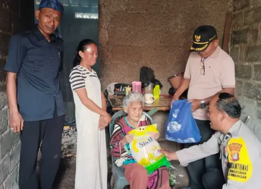 Bhabinkamtibmas Kelurahan Pengasinan, Polsek Bojongsari, memberikan bantuan sembako kepada warga lansia yang tinggal di rumah tidak layak huni di Sawangan, Depok. (Sumber: Poskota/Angga Pahlevi)