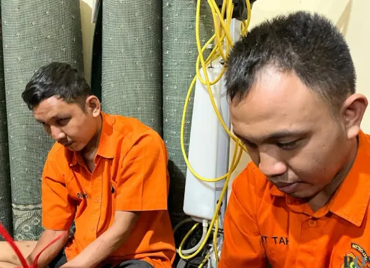 Dua tersangka kasus penembakan hansip hingga tewas di Mapolda Metro Jaya, Jakarta Selatan, Senin, 10 November 2025. (Sumber: Poskota/Pandi Ramedhan)