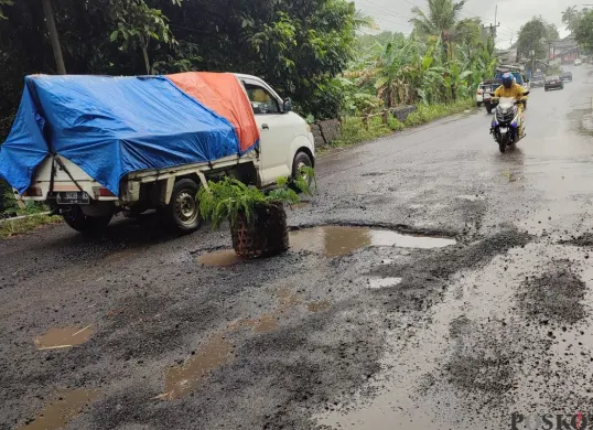 Kondisi jalan nasional di jalur Pandeglang-Labuan terlihat berlubang. (Sumber: Poskota/Samsul Fatoni)