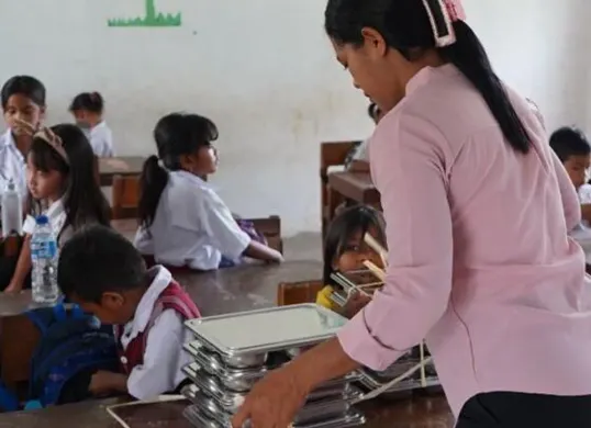 Seorang guru membagikan baki makanan kepada para siswa di SD Katolik Wee Pangali, Sumba Barat Daya, sebagai bagian dari program Makan Bergizi Gratis (MBG) yang mendorong kehadiran dan semangat belajar anak-anak. (Sumber: Istimewa)