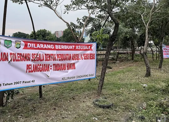Ilustrasi, spanduk larangan melakukan aktivitas prostitusi dipasang di taman Jalan Daan Mogot, Cengkareng, Jakarta Barat, pada Sabtu, 15 November 2025. (Sumber: POSKOTA | Foto: Pandi Ramedhan)