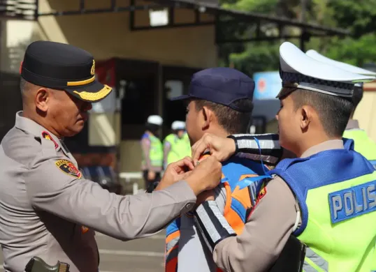 Wakapolres Metro Depok AKBP Akmal menyematkan pin ke masing-masing perwakilan personil di Apel Pasukan Operasi Zebra Jaya 2025 di Lapangan Mapolrestro Depok. (Sumber: Istimewa)
