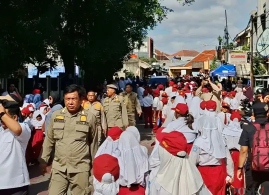 Ribuan pelajar memenuhi Jalan Komodo Raya, Kelurahan Kayuringin Jaya, Kecamatan Bekasi Selatan, Kota Bekasi, untuk menyambut kedatangan Presiden Prabowo Subianto. Senin 17 November 2025. (Sumber: Poskota/Nurpini Aulia Rapika)