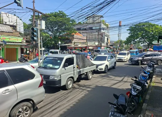 Kemacetan lalu lintas di kawasan permukiman dan pertokoan di Depok, dengan sejumlah mobil dan motor saling berebut ruang di persimpangan jalan. (Sumber: Poskota/Angga Pahlevi)