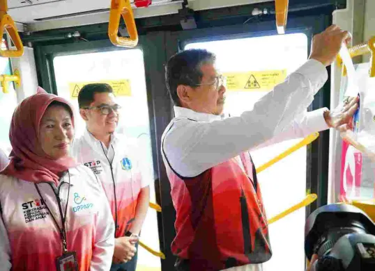 Sekda Pemprov DKI Jakarta, Marullah Mattali, saat menempelkan stiker di bus Transjakarta, pada Rabu, 26 November 2025. (Sumber: Dok Kominfotik Pemprov Jakarta)
