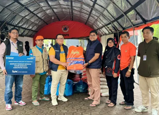 Corporate Secretary Bank Mandiri, M Ashidiq Iswara (ketiga dari kiri) menyerahkan bantuan untuk warga terdampak bencana alam di Sumatera. (Sumber: Corsec Bank Mandiri)