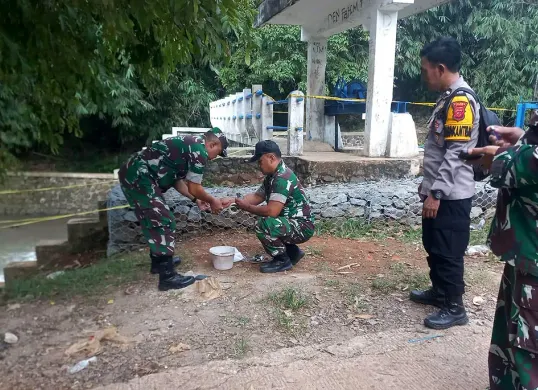 Petugas mengevakuasi granat manggis yang ditemukan di pintu air Sikabayan, Desa Babakan, Kecamatan Ciseeng, Kabupaten Bogor, Minggu 30 November 2025. (Sumber: Dok Polsek Parung)