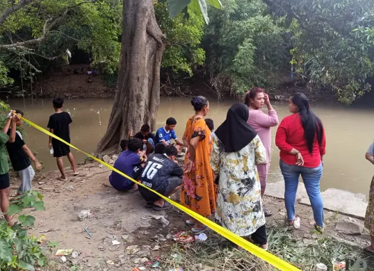 Warga menyaksikan operasi pencarian tenggelamnya tiga bocah di Kali Cikarang, Kampung Tanah Baru, Kelurahan Karang Baru, Kecamatan Cikarang Utara, Kabupaten Bekasi. (Sumber: POSKOTA | Foto: Nurpini Aulia Rapika)